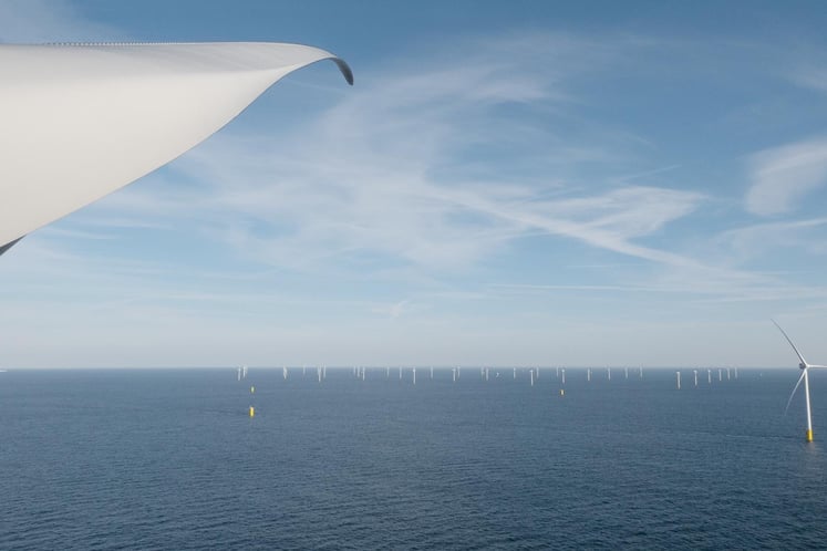 View from an offshore wind mill over the sea and more wind mills in the distance. The foreground includes the blade of a wind mill, framing the view. View from an offshore wind mill over the sea and more wind mills in the distance. The foreground includes the blade of a wind mill, framing the view.